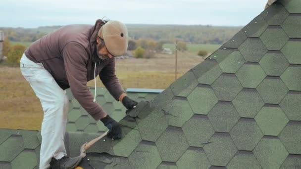 Reparatie van het dak van een residentieel gebouw. Ontmanteling van zachte tegel. — Stockvideo