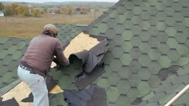 Reparatie van het dak van een residentieel gebouw. Ontmanteling van zachte tegel. — Stockvideo