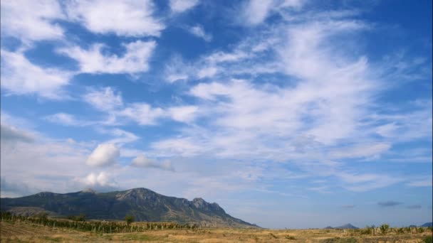 Montanhas contra o céu azul com nuvens brancas. As nuvens circulares atravessam o céu azul. melhores tipos de cadeias de montanhas. Bela vista das montanhas. melhor vídeo de penhascos íngremes. melhor lugar para um — Vídeo de Stock