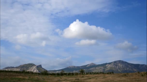 Montanhas contra o céu azul com nuvens brancas. As nuvens circulares atravessam o céu azul. melhores tipos de cadeias de montanhas. Bela vista das montanhas. melhor vídeo de penhascos íngremes. melhor lugar para um — Vídeo de Stock