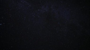 Yıldızlı gece gökyüzü. Karanlık gece gökyüzünde parlayan yıldız. Gece gökyüzünde sürüklenen ışık bulutlar. Zaman atlamalı