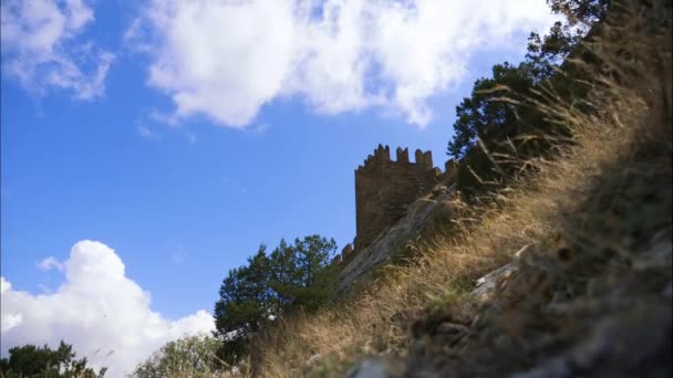 Montagne contro il cielo blu con nuvole bianche. Le nuvole di cirri attraversano il cielo blu. Parte del muro della fortezza sullo sfondo della città situata nella valle . — Video Stock