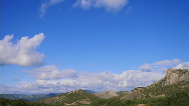 Гори проти блакитного неба з білими хмарами. Круглі хмари проходять через блакитне небо. кращі види гірських хребтів. Прекрасний вид на гори. найкраще відео крутих скель . — стокове відео