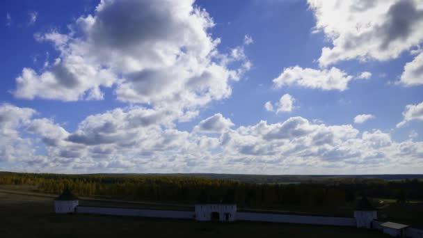 Pared del monasterio sobre un fondo. Paisaje de otoño. Muralla colegiata en medio del bosque amarillo . — Vídeo de stock