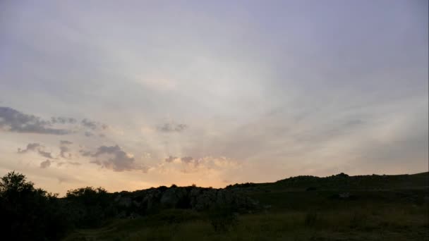 Hory v pozadí šedé mraky. Temné mraky obklopují vrcholky pohoří. slunce vychází z hor. Stepní trávy a větví stromů na pozadí úsvitu. nejlepší místo pro — Stock video