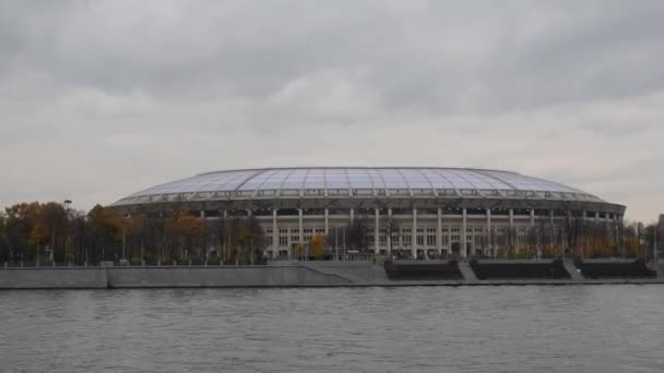 Moskevské Lužniky. Rekonstrukce paláce sportu. Pohled z řeky Moskvy přes Luzhnetskaya nábřeží. Stadion proti šedá obloha s mraky. Kamera v pohybu. — Stock video