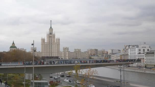 Moskau, Russland, Park zaryadye Blick auf die Aussichtsplattform in Form eines Bumerangs über den Fluss Moskau, Hochhaus auf dem kotelnicheskaya Damm. die Bewegung von Fahrzeugen auf der Uferpromenade. — Stockvideo