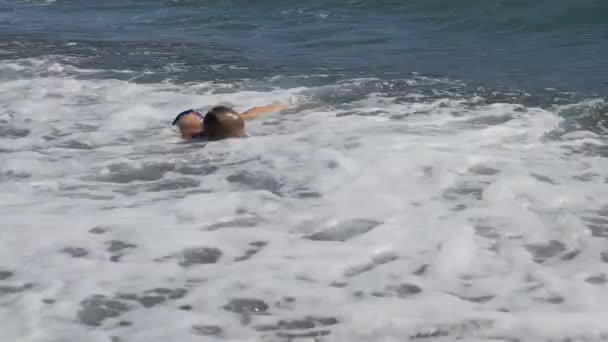Baby på stranden, i den maritima våg. liten pojke i svart glas för dykning dyk under havet vågen. — Stockvideo