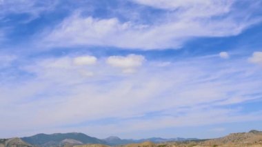 Mavi gökyüzü ile beyaz bulutlar dağlar. Cirrus bulutlar mavi gökyüzünde çalıştırın. dağ sıralarının iyi türleri. Dağların güzel manzara. en iyi video dik kayalıklarla. en iyi yer için bir