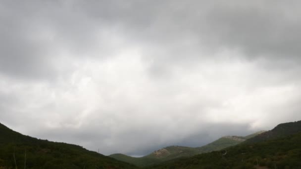 Berge im Hintergrund grauer Wolken. Sonnenstrahlen verlaufen entlang der Bergrücken. Dunkle Wolken umhüllen die Gipfel der Berge. Zeitraffer. Bewegung im Rahmen. schöne reizvolle Landschaft. — Stockvideo