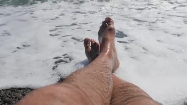 Mens hairy legs in sea surf. Crossed bare legs. — Stock Video