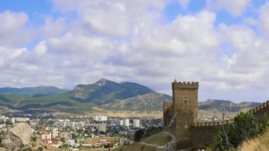 Ceneviz Kalesi, Sudak, Crimea. Mavi gökyüzü ile beyaz bulutlar dağlar. Cirrus bulutlar mavi gökyüzünde çalıştırın. Vadide bulunan şehir arka plan üzerinde kale duvarının
