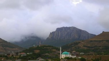 Arka planda gri bulutlar dağlar. Kara bulutlar dağlar başında örtmek. dağ sıralarının iyi türleri. Dağların güzel manzara. en iyi video dik kayalıklarla. Eski Cami