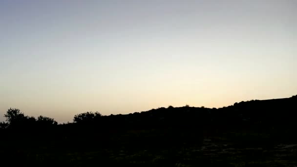 Montañas en el fondo de nubes grises. Nubes oscuras envuelven las cimas de las montañas. el sol sale de las montañas. Hierba estepa y ramas de árboles sobre el telón de fondo del amanecer. Movimiento en el — Vídeo de stock