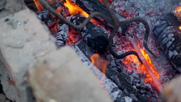 Blacksmith works metal. Craftsman, the Highlander on private smithy in the village. Burning logs in the blacksmiths furnace. Taking out the hot hot billet from the hearth using ticks. Slow motion — Stock Video