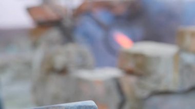demirci metal çalışır. Usta, Highlander köyde özel smithy üzerinde. sıcak metal fırın üzerinden çek. Sıcak metal kütük akarları ile transferi için örs. Demirci forge