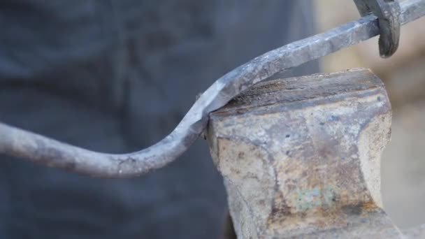 Smid werkt metaal. Werkman, de Highlander op particuliere smithy in het dorp. snijden van ruwijzer op een vice met behulp van slagen met een slee hamer. — Stockvideo