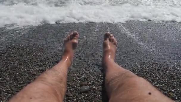 Mens hairy legs in sea surf. Parallel lying bare legs. — Stock Video