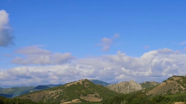 Montañas contra el cielo azul con nubes blancas. Las nubes circulares atraviesan el cielo azul. mejores tipos de cadenas montañosas. Hermosa vista de las montañas. mejor video de acantilados empinados. Movimiento en el marco — Vídeos de Stock