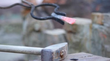 demirci metal çalışır. Usta, Highlander köyde özel smithy üzerinde. Sıcak metal kütük akarları ile transferi için örs. Demirci üzerinde forge bir balyoz yatıyor. Ağır çekim