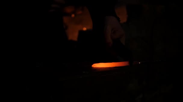 Smid werkt metaal. Werkman, de Highlander op particuliere smithy in het dorp. Hot rod zet op het aambeeld, de meester raakt hem met een moker. Op de smeden-forge ligt een moker — Stockvideo