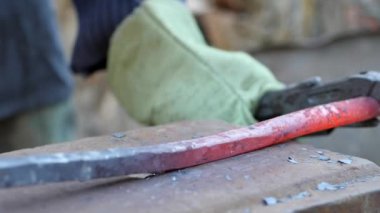 demirci metal çalışır. Usta, Highlander köyde özel smithy üzerinde. Balyoz sıcak metal üzerinde darbeler. kütük gaz anahtarı ile düzenlenmektedir. Ağır çekim