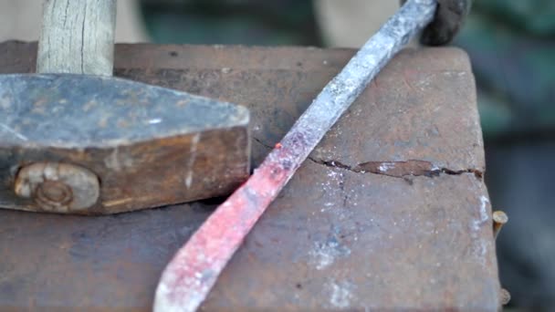鍛冶屋は金属を動作します。職人の村のプライベート鍛冶のハイランダー。鍛冶フォージにハンマーがあります。鍛冶屋は、ハンマーで溶銑からスケールをノックします。遅い — ストック動画