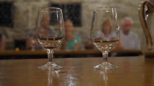 ワインのテイスティング ルームで試飲。クリミアのワイナリー周辺の遠足。テーブルの上の Bakaly スタンド。ワインはグラス皿に注がれています。ソムリエは、彼のガラスに手を差し出します。サニーバレー — ストック動画