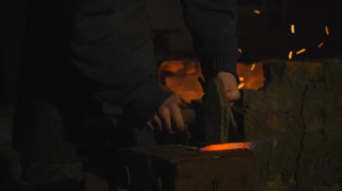 Genç demirci metal çalışır. Usta, Highlander köyde özel smithy üzerinde. Metal kütük şekillendirme. Usta balyoz İşlenecek parçanın bıçak atıyor. Farklı kıvılcımlar