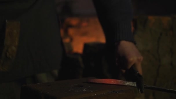 鍛冶屋は金属を動作します。職人の村のプライベート鍛冶のハイランダー。金属片を形成します。職人のハンマーを打つワーク ナイフ。火花を別の方向に — ストック動画