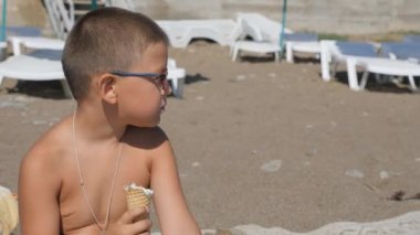 Çocuk dondurma yiyor. çocuğun yüzünü gıda ile bulaşmış. Çocuk bir gözleme koni gelen dondurma yiyor.