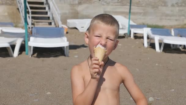 El niño come helado. chico manchó su cara con comida. Niño comiendo helado de un cono de gofre negro . — Vídeo de stock