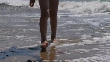 Çocuk sörf gidiyor. Arka plan çocuk ayağa dalgaların. deniz suyu uzak ayak izi yıkar