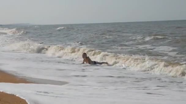 Bebek Plajda, deniz dalgası. İki erkek üzerinde sörf oynamak altın kum. Çocuğun kafa ile dalga kapsar. — Stok video