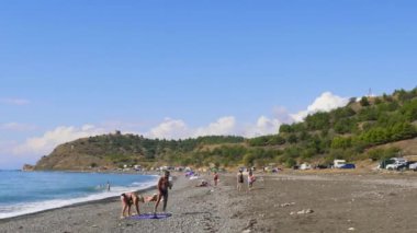 6 Eylül 2018, Morskoye Köyü, Kırım'da, yazı işleri. İnsanlar mayolu bir çakıl plajı deniz kenarında üzerinde. Mavi gökyüzü ile beyaz bulutlar dağlar. Cirrus bulutlar mavi gökyüzünde çalıştırmak