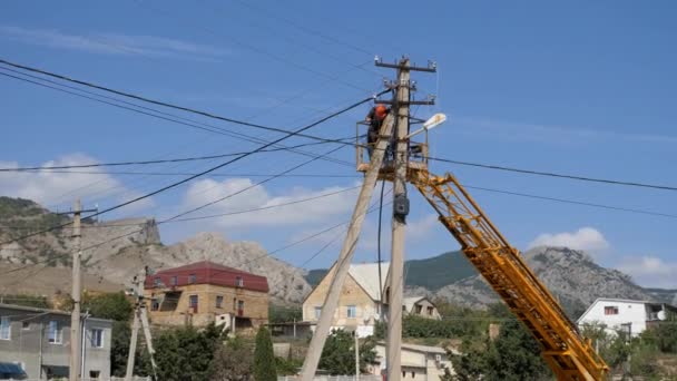 Eletricistas na altura dos fios de montagem. Subir na altura por meio da máquina de uma torre — Vídeo de Stock