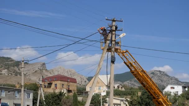 Eletricistas na altura dos fios de montagem. Subir na altura por meio da máquina de uma torre — Vídeo de Stock