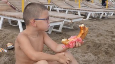 Çocuk sahilde peynir ekmek yemek