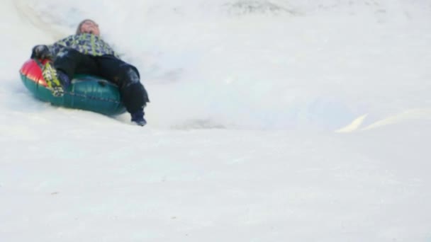 Зимова їзда на сирниках зі сніжними міськими гірками — стокове відео