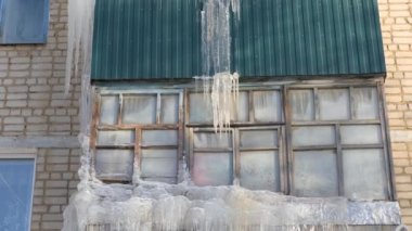 Kış. Çatı ve bir daire binanın balkonları asılı icicles