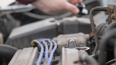 İç yanmalı motorda yağ doldurun. Metal bir bidondan araba motorunun deliğine akan bir sıvı jeti.