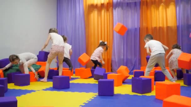 Salle de jeux pour enfants. Jouer avec des cubes de mousse . — Video