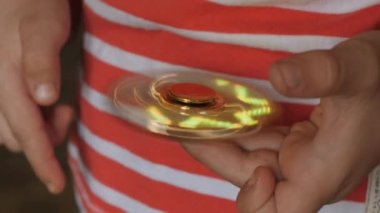 Dönen oyuncak, spinner, açık saçlı bir çocuğun elinde.