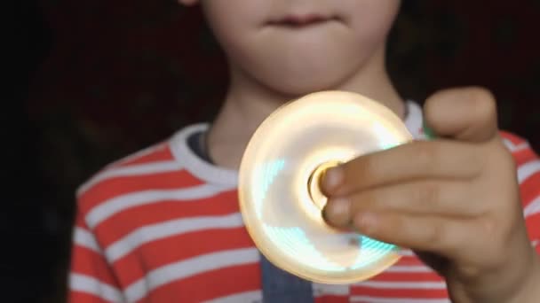 Spinning toy, spinner, in the hands of a fair-haired boy. — Stock Video