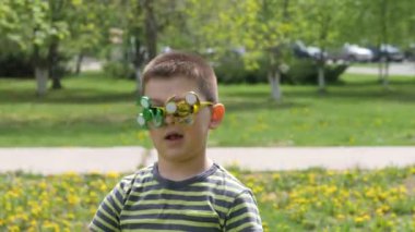 Bardaktaki spinner dönüyor. Sokakta eğlenceli. Sarı çiçekler, karahindiba bir arka plan üzerinde çocuk.