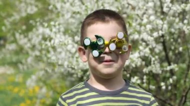 Bardaktaki spinner dönüyor. Sokakta eğlenceli. Kiraz ağacının çiçek açan beyaz çiçekleri arka planda bir çocuk.