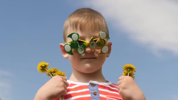 Spinner on the glasses is spinning. Fun on the street. Baby boy against the blue sky. — Stock Video