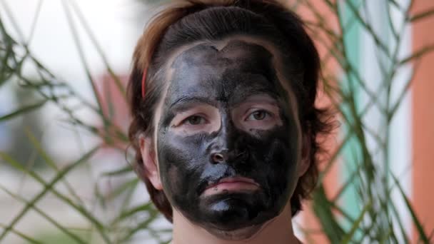 Cara femenina cubierta con una máscara negra . — Vídeo de stock