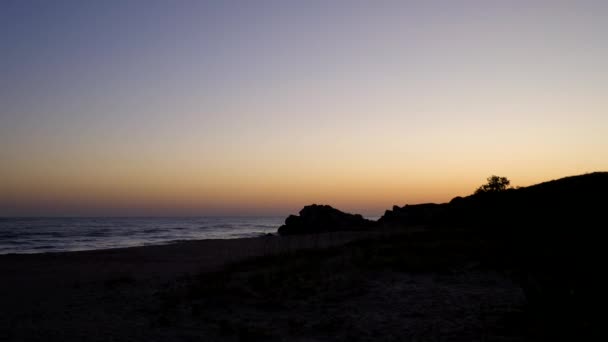 Nascer do sol na praia. O sol nasce de trás das montanhas . — Vídeo de Stock