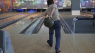 Bowling 'de zaman geçirmek. Pistte paten yapan toplar lobutları devirmek için..